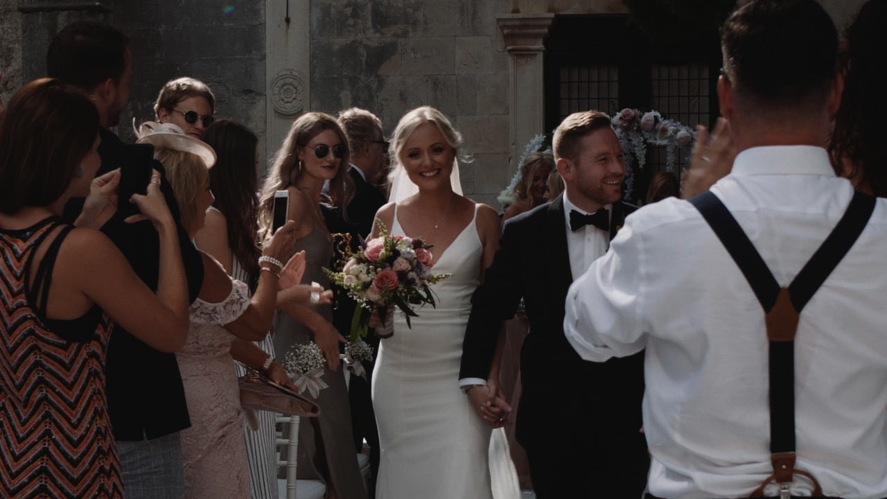 St. Mark Monastery vjenčanje Hvar, bride and groom walking out after wedding ceremony as guests applaud